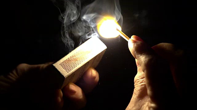 慢镜头:点燃火柴的手的特写视频素材