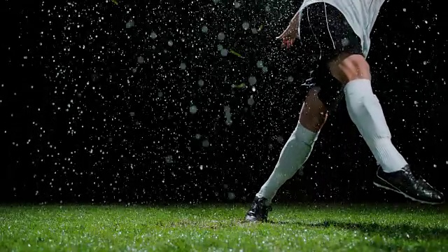 足球运动员在雨中踢半空中的球视频素材