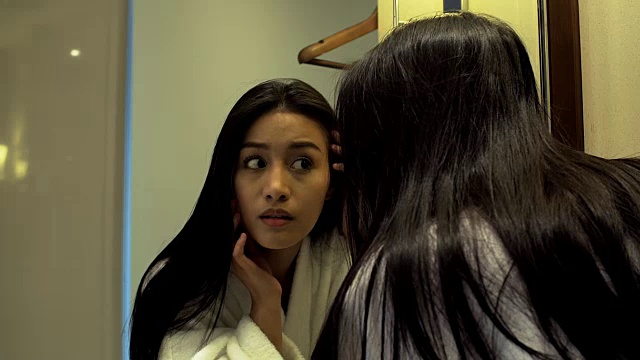 4K:美丽的亚洲女人看着浴室镜子视频素材