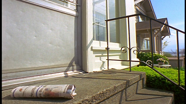 慢镜头特写报纸落在房子的水泥门阶上/西雅图，华盛顿视频素材