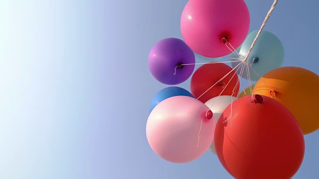 五颜六色的气球在蓝天中飞翔视频下载