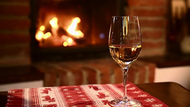 壁炉边放着一杯白葡萄酒视频素材