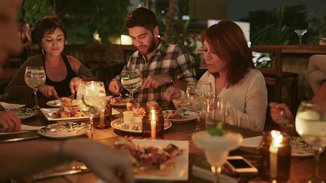 一群朋友在一家餐馆吃饭/哥伦比亚麦德林视频素材