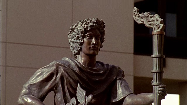 镜头从喷泉中倾斜而上，喷泉中有希腊神墨丘利的青铜雕像和火把。视频下载