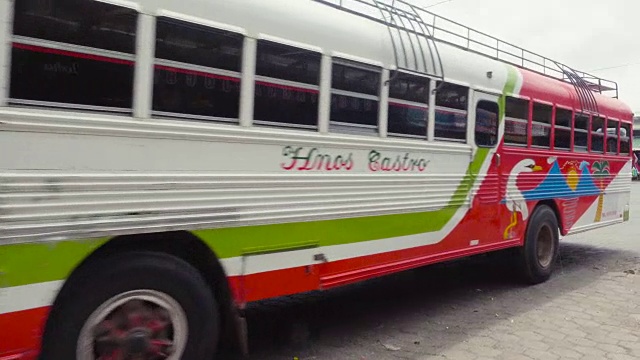 里瓦斯尼加拉瓜汽车站正在拍摄/放映。一辆五颜六色的公共汽车从右向左横穿而过。当地人、旅行者和人力车穿过这个中美洲小镇的街道。视频素材