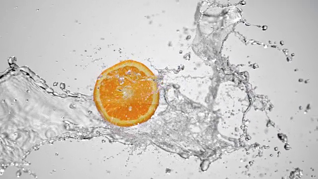SLO MO白色背景上的水花中的一片橘色视频下载