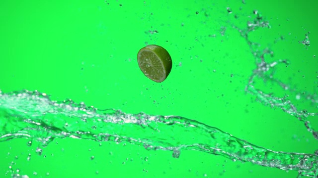 SLO MO石灰一半击中水溅在绿色的背景视频素材