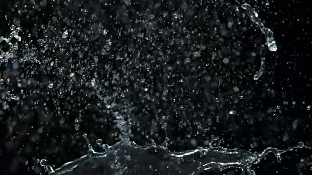 SLO MO番茄被水泼在空中的黑色背景视频素材
