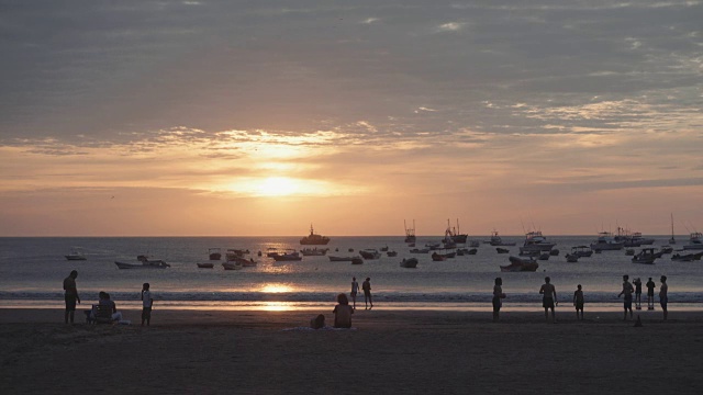 圣胡安德尔苏尔海滩与美丽的云彩天空。以年轻人的剪影为前景，以渔船为背景。视频下载