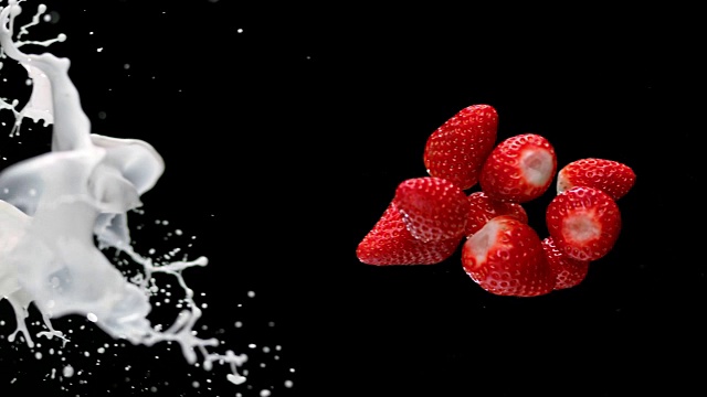 草莓碰撞，牛奶溅在空气中视频素材
