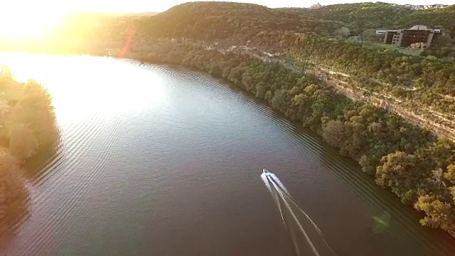 追逐快艇在德克萨斯州奥斯汀湖上的太阳空中跟随场景与船加速过特拉维斯湖或镇湖或科罗拉多河的水视频素材