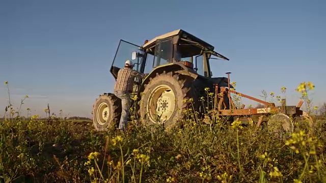 在田里开拖拉机的农民视频素材