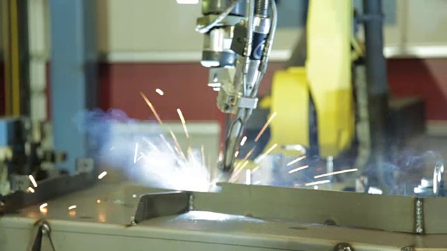 在美国的一家制造工厂里，火花从机器人焊机中飞溅出来。视频素材