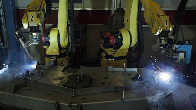 在美国的一家制造工厂里，自动焊接机器人系统的双臂一起工作创造部件。视频素材