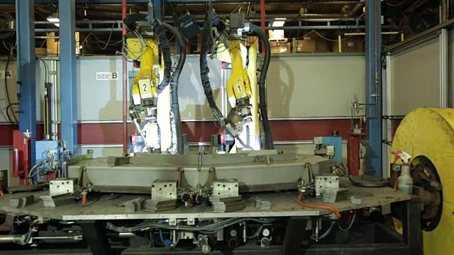 在美国一家制造工厂里焊接部件的机器人手臂。视频素材