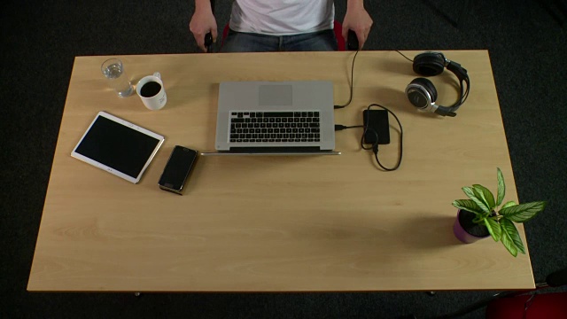 桌子上方放着笔记本电脑视频下载