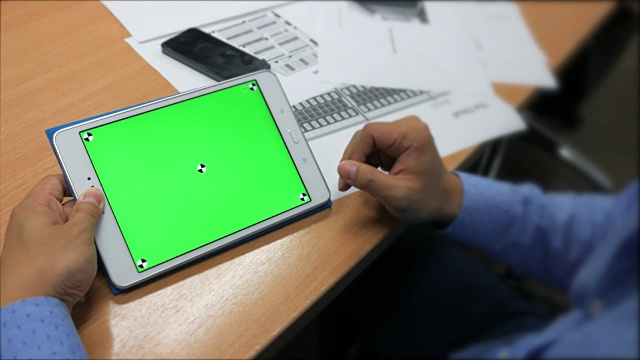 一名男子手持一台绿色屏幕的空白平板电脑视频素材