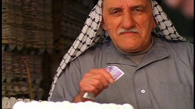 高级阿拉伯鸡蛋小贩在卡菲耶堆叠鸡蛋+持有货币/耶路撒冷老城视频下载