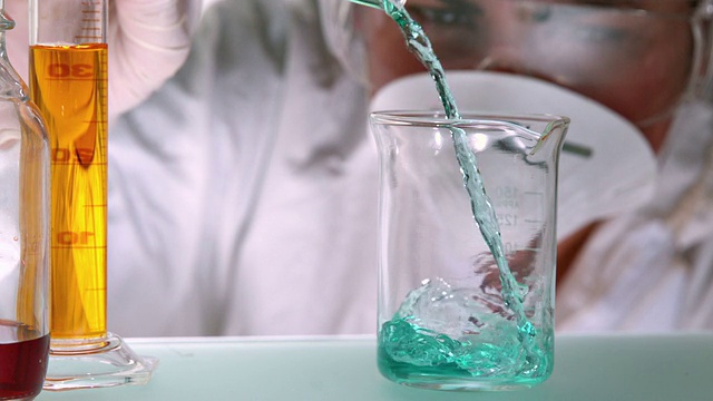 科学家将蓝绿色液体倒入烧杯视频素材