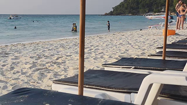 ิpanning:沙滩上的白色沙滩椅视频素材