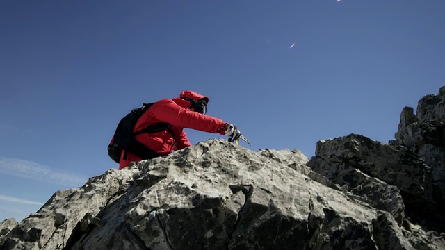 登山者在山上互相帮助翻越岩石视频素材