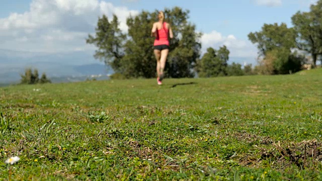镜头前的女运动员在草地上奔跑视频素材