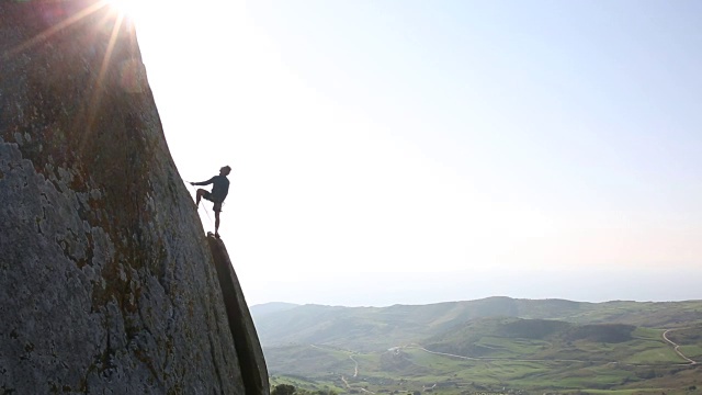 攀登者从岩石表面高处往外看视频素材