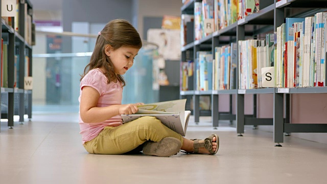 小女孩坐在图书馆的地板上看书视频下载