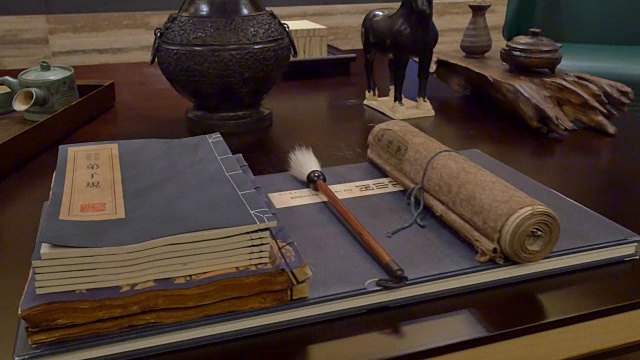 书籍和中国书法工具摆放在现代书房的书桌上视频下载