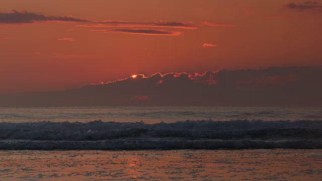 橙色的太阳从大西洋上空的低云上升起，鸟儿在飞翔视频下载