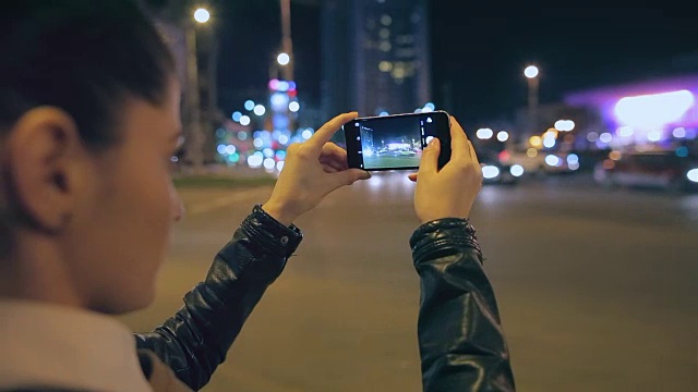城里有个女人正在用她的智能手机拍照。视频素材