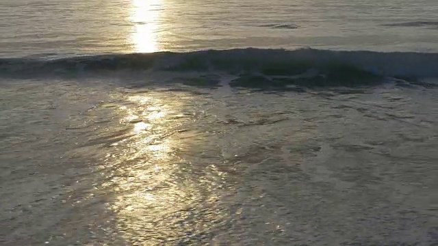 阳光下温和的银色海浪拍打着沙滩视频下载