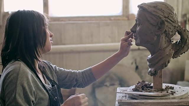 年轻的艺术家正在创作一个女性头部雕塑视频下载