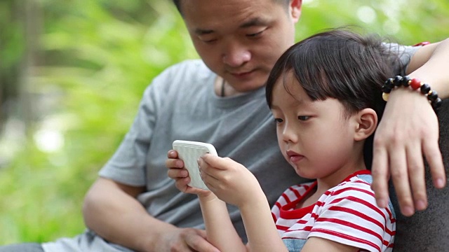 使用智能手机的孩子和父亲视频素材