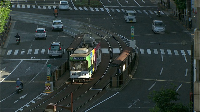 一辆有轨电车在长崎一条繁忙的道路上行驶。视频素材