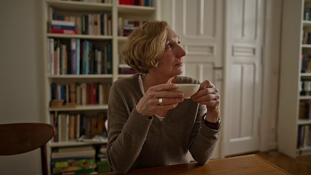 一位迷人的老妇人正在享受着一杯热茶视频素材