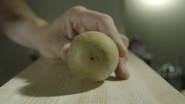 放大镜头，一个猕猴桃被切成两半放在厨房砧板上。视频下载