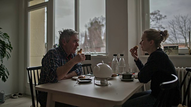 一个活跃的老人和他迷人的年轻女儿在五点钟的下午茶视频素材