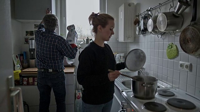 一个活跃的老男人和他迷人的年轻女儿在烹饪视频素材
