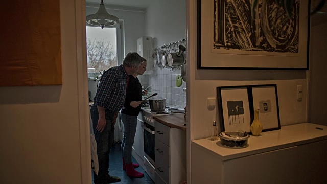 一个活跃的老男人和他迷人的年轻女儿在烹饪视频素材