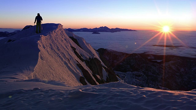 日落时分，穿着雪鞋穿过山脊的人视频素材