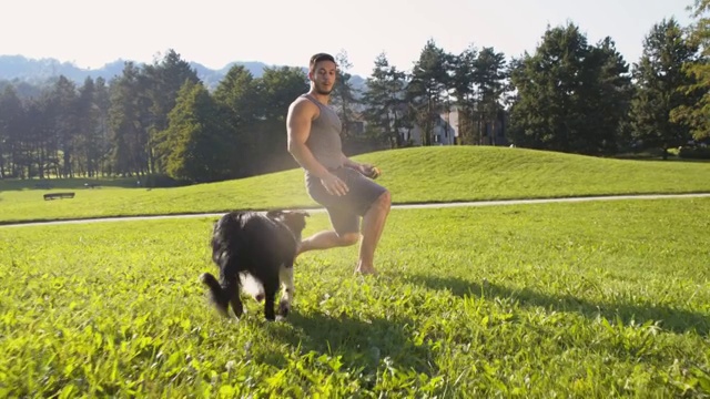 年轻男子训练他的狗接球视频素材