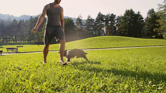 SLO MO Man和他的狗在公园玩视频素材