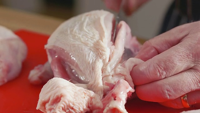 ECU TD的厨师切生鸡肉把乳房从核心红切菜板/新港,英国南威尔士aE视频素材