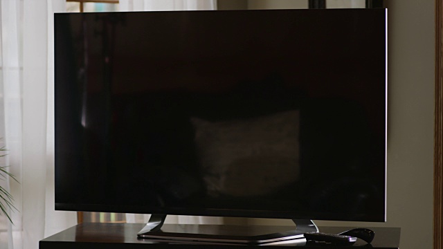 近距离的大屏幕平板电视坐在一张桌子上的客厅。视频下载