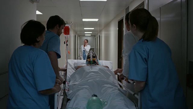 医生和他的医疗团队手动给轮床上的病人通气视频素材