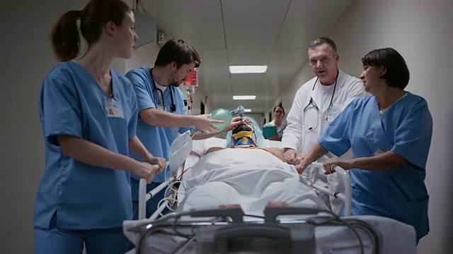 医生和护士在医院走廊上运送一名男性病人视频素材