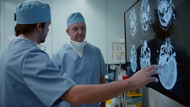 两位男外科医生正在讨论头部CT扫描视频下载