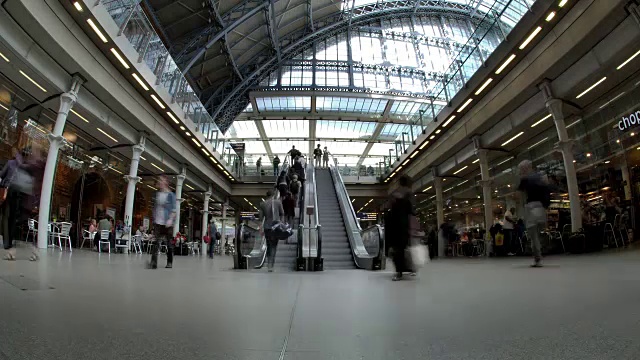 在圣潘克拉斯国际火车站，通勤者和游客使用自动扶梯连接站台和购物中心视频下载