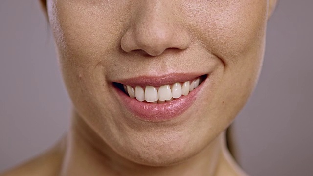 一个年轻的亚洲女人微笑的嘴唇视频素材